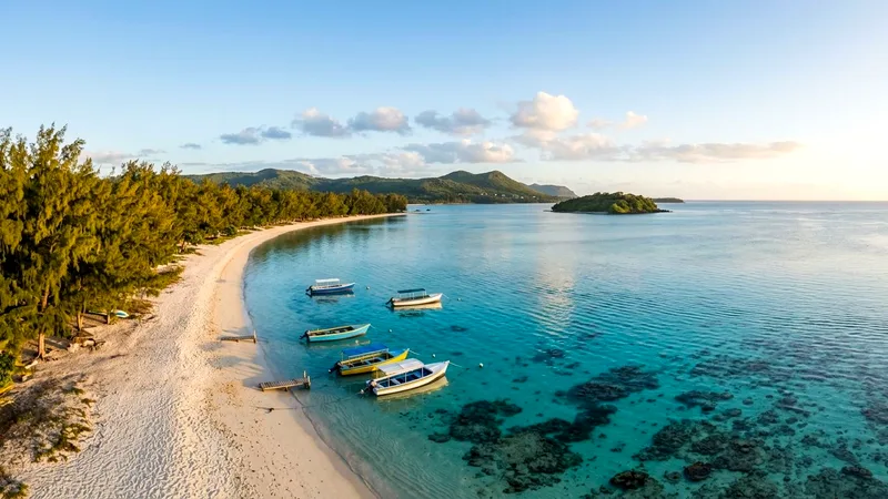 Turquoise Blue Bay lagoon with moored boats and a white beach in Mauritius.